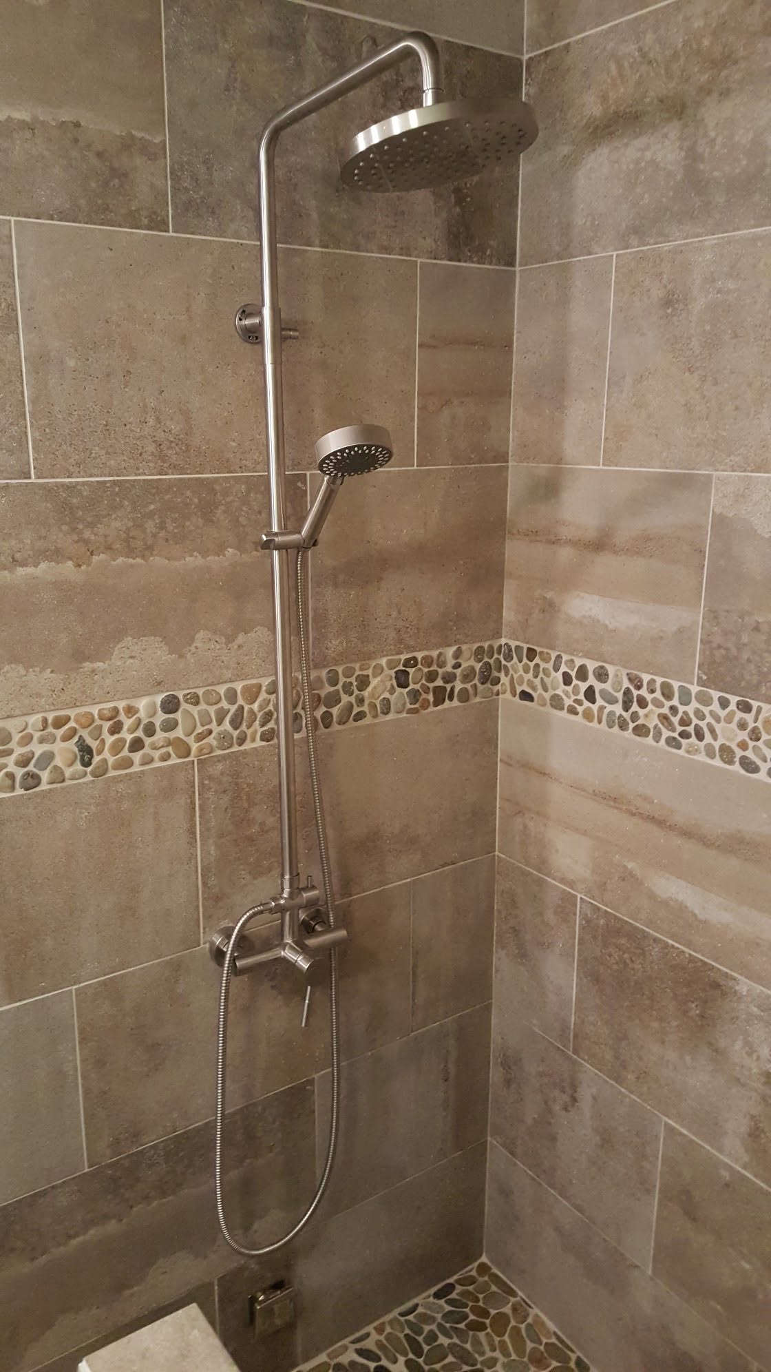 Custom tile shower with river-rock accent band and stainless rain shower fixture